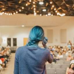 Woman giving a speech in front of a crowd.