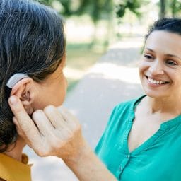 Woman with hearing aid chatting with her friend.