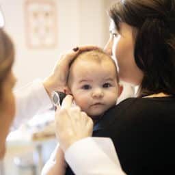 An audiologist examining a baby's ear.
