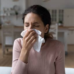 Woman blowing her nose