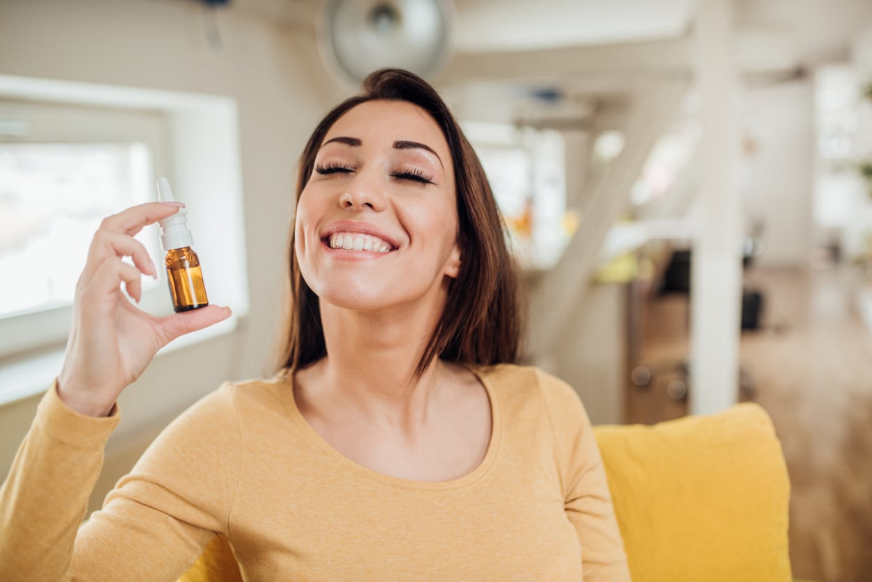 Woman holding an allergy drop vial.
