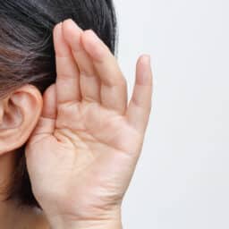 Close up of person with hand behind ear