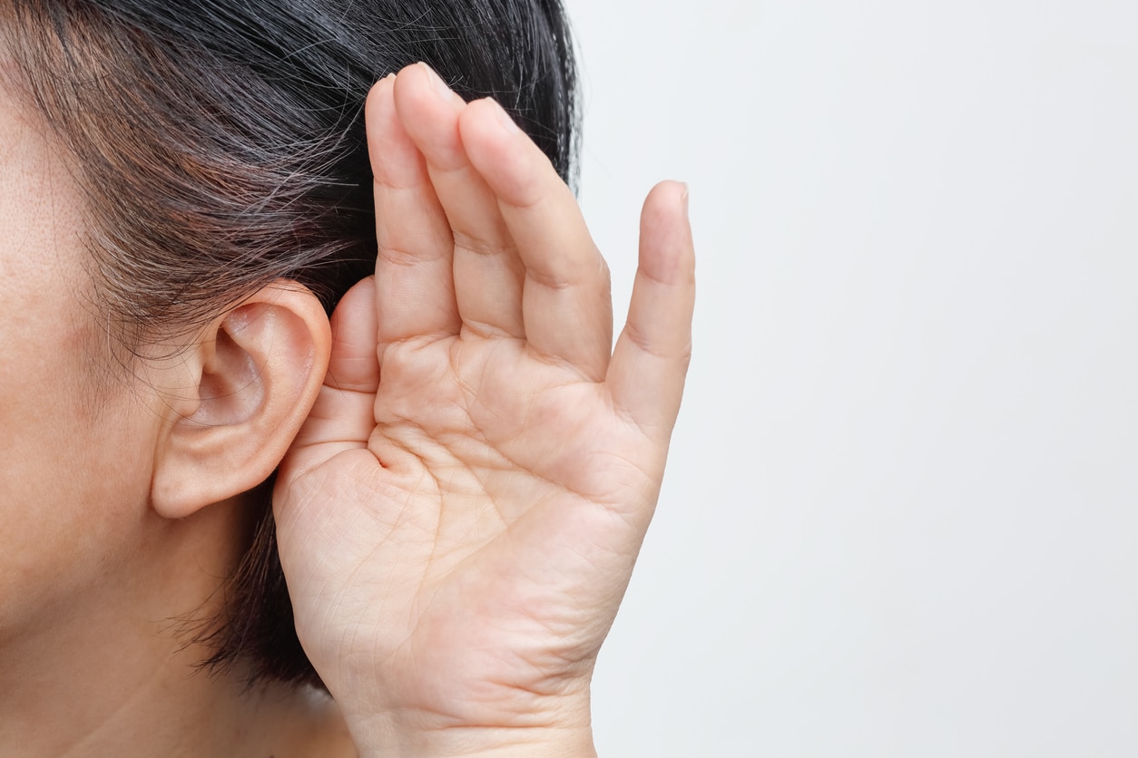 Close up of person with hand behind ear