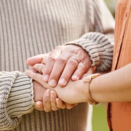 Close-up of two people holding hands, emotional support