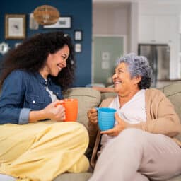 Woman talking to her mother on the couch.