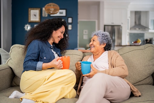 Woman talking to her mother on the couch.