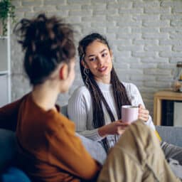 Two roommates are having a conversation in the living room