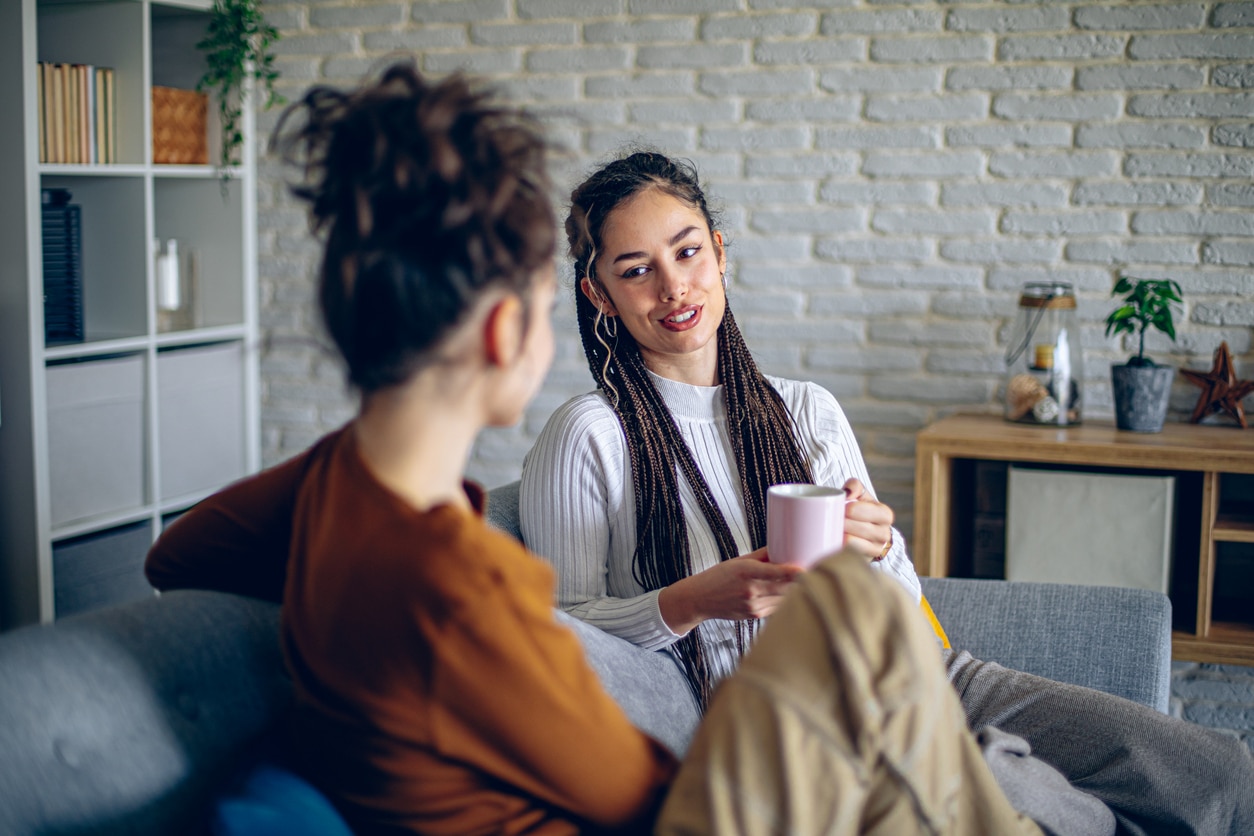Two roommates are having a conversation in the living room.